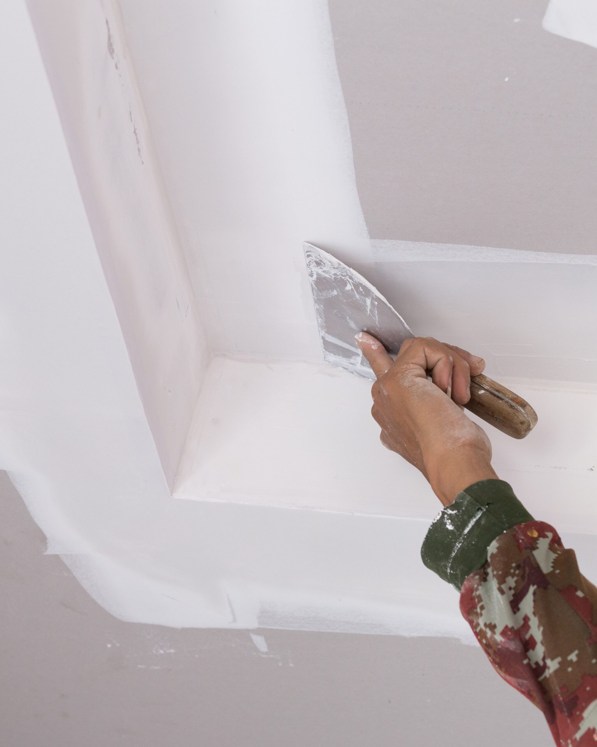 hand of worker using gypsum plaster ceiling joints